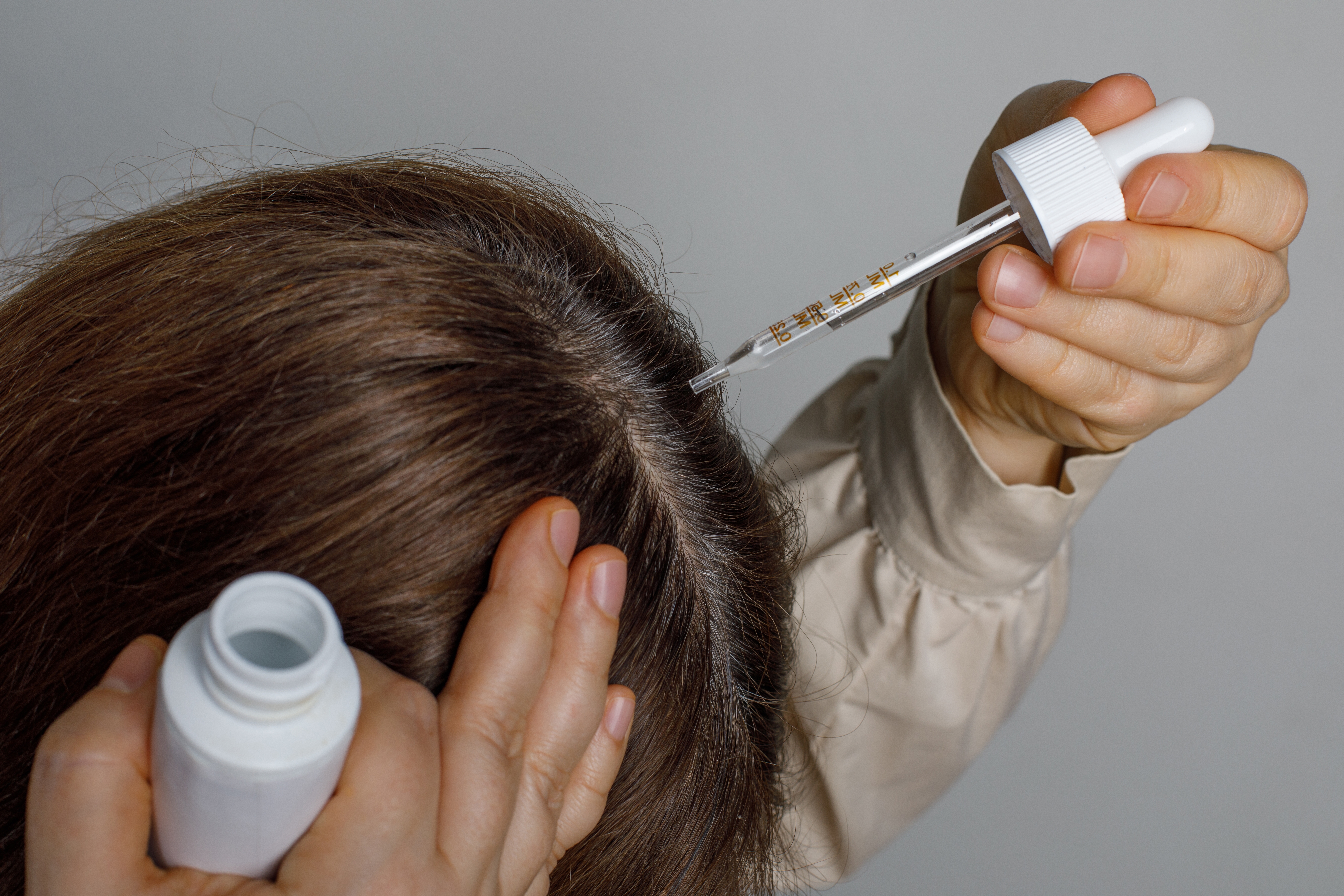 close up op een vrouw die haar haar behandeld met een serum